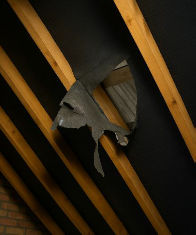 Torn and displaced sarking felt visible from loft